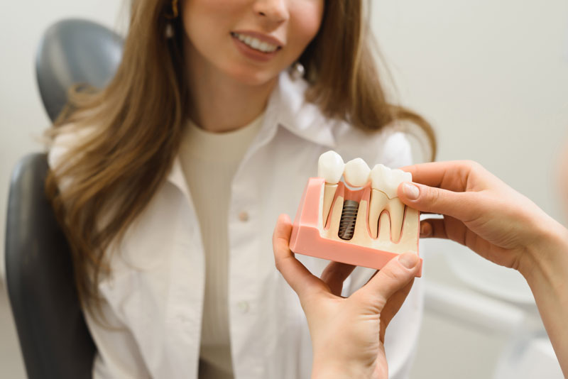 Dental Patient Getting Shown A Dental Implant Model During Her Consultation in Waco, TX