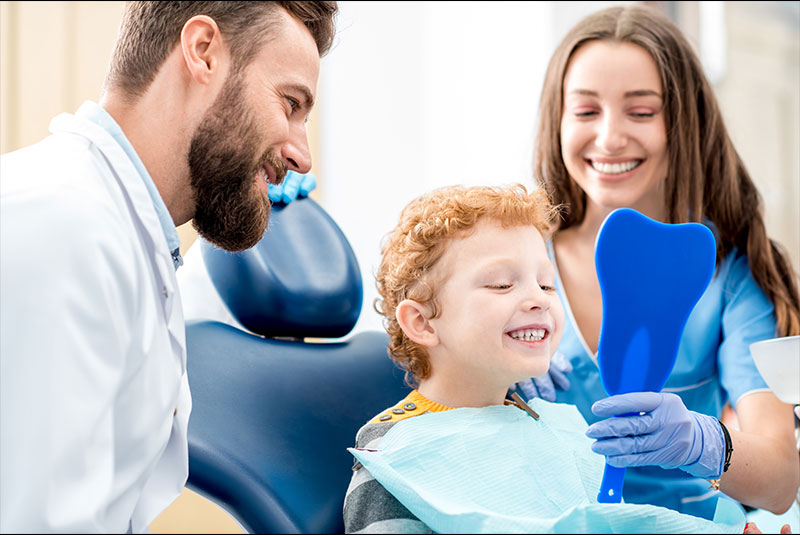 Child Patient and dentist and hygienist within dental practice room